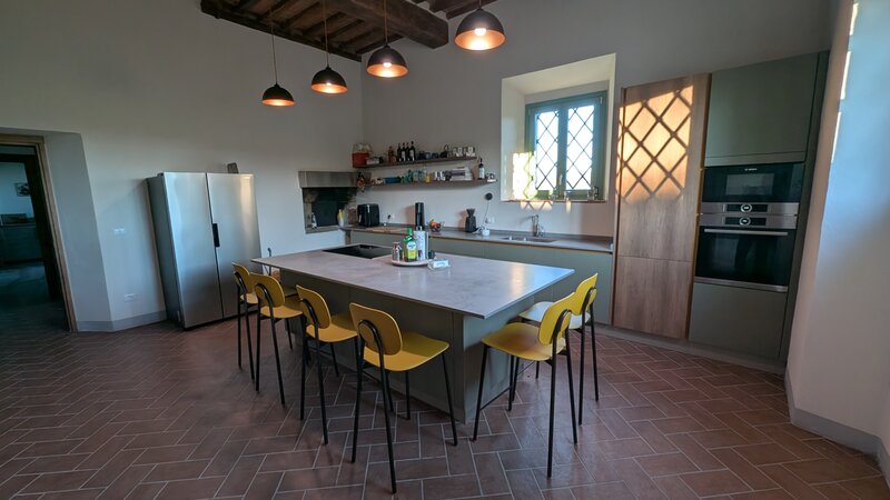 La cucina, con l'isola e le sedie gialle.