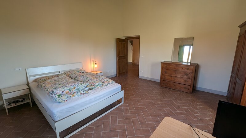 Camera Giotto: letto matrimoniale con lampada accesa, luce serale