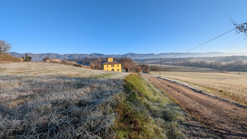 Strada sterrata attraverso il Mugello, leopoldina toscana in distanza